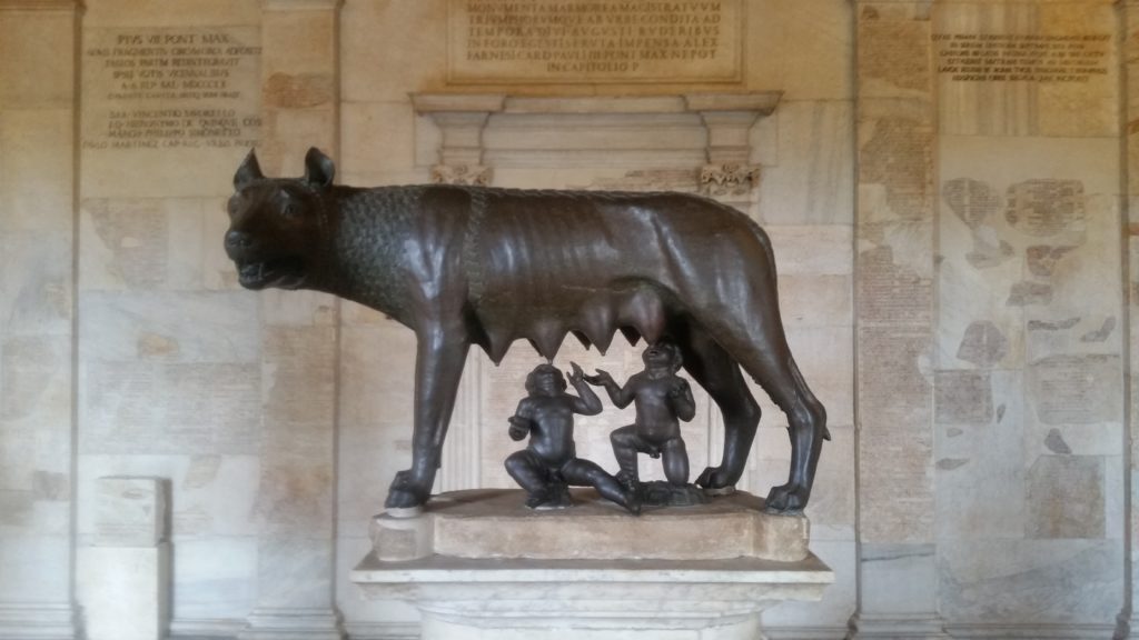 bronze of an animal and two people underneath her.