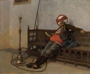 man seated with a hookah pipe