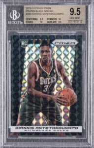 giannis antetockounmpo holding a basketball for in a Panini prizm black mosaic basetball card in a milwaukee bucks uniform