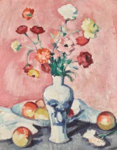 flowers in a vase with fruit on a table