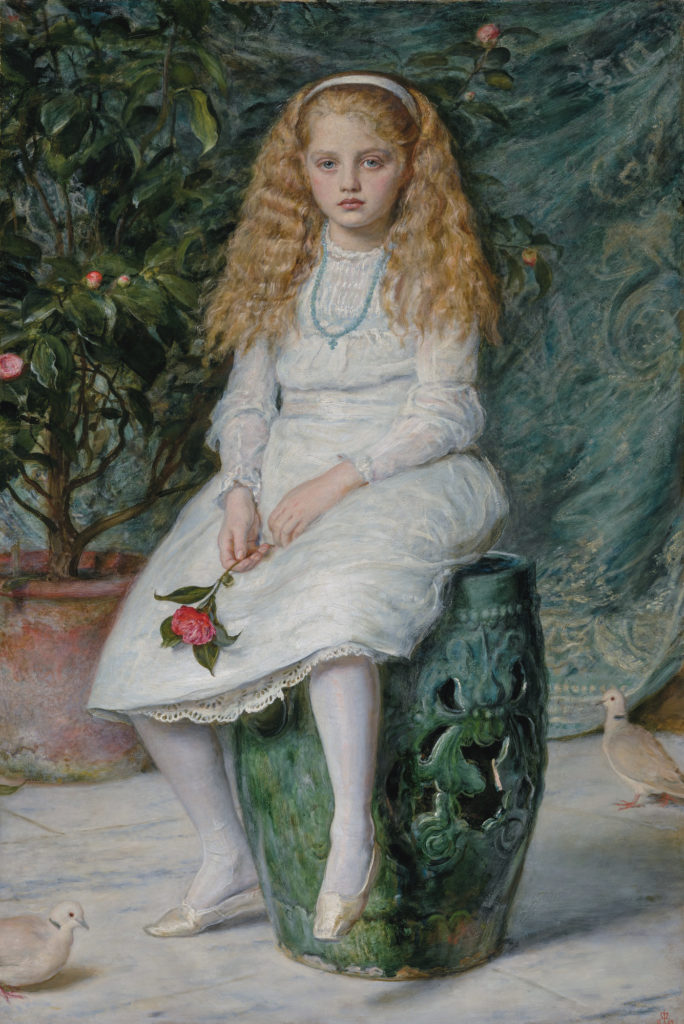 young girl seated with a flower in her hand