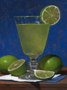 a glass with a cocktail and limes