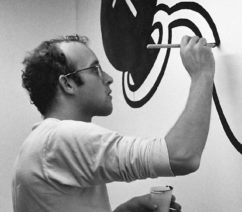 A black-and-white photo of Keith Haring at work