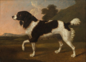 A black and white spaniel pointing to the left, in a wooded landscape with a church spire beyond; painted by George Stubbs, sold at Bonhams New Bond Street