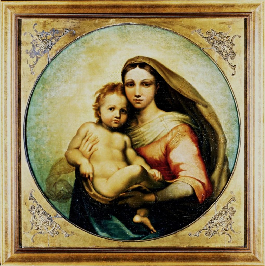 A circular painting of a woman and her son, likely a Madonna and Child, against a plain background. The woman is veiled and dressed in a pink robe, while the infant is completely naked. The painting is fit into a square frame, with decorative, triangular wooden pieces inserted at the edges to make the canvas fit the frame.