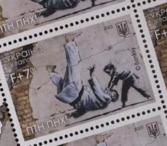 A postage stamp featuring a graffiti mural of a small boy and a brown man sparring in judo outfits. The boy is throwing the man onto his back. The stamp also features the trident of Ukraine's coat of arms in the top right, and an abbreviated Ukrainian phrase that roughly translates to "Putin is a Dickhead!" in the bottom left.