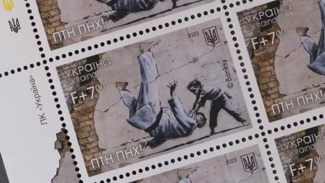 A postage stamp featuring a graffiti mural of a small boy and a brown man sparring in judo outfits. The boy is throwing the man onto his back. The stamp also features the trident of Ukraine's coat of arms in the top right, and an abbreviated Ukrainian phrase that roughly translates to "Putin is a Dickhead!" in the bottom left.