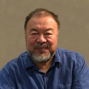 Chinese dissident artist Ai Weiwei in a blue shirt against a beige background
