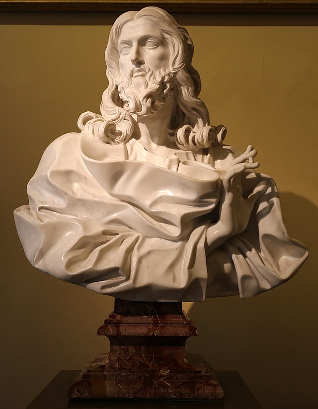 A marble bust of Christ draped in robes and his right hand extended in benediction.