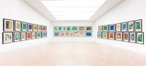 A colorful lithograph series displayed in rows on three walls of a gallery.