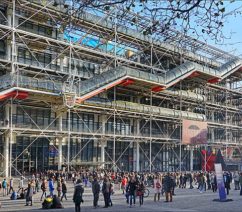 The Centre Georges Pompidou: a large, modern building that appears like there is scaffolding across the entire front as well as a long, jagged, tubular stairway running across the entire front.