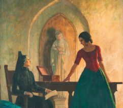 A young woman standing to the right, speaking to a seated older woman all in black, with the beige background of a stucco wall featuring a statue of the Virgin Mary behind them