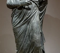 A headless ancient Roman bronze statue of a man in a toga formerly held by the Cleveland Museum of Art.
