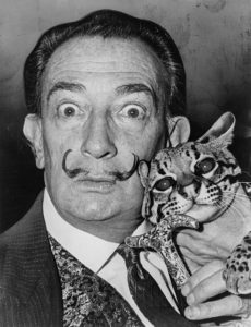 A black-and-white photograph of the surrealist artist Salvador Dalí holding his pet ocelot.