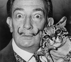 A black-and-white photograph of the surrealist artist Salvador Dalí holding his pet ocelot.