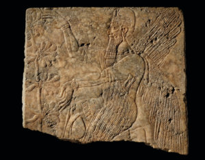 A relief sculpture of a winged man next to a tree made on a block of gypsum.