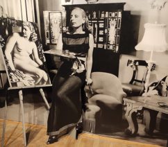 A black-and-white cutout of the artist Tamara de Lempicka shown against a black-and-white display and an easel