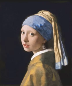 A bust-length portrait of a young woman against a dark background with a pearl earring and a blue and yellow turban-style headdress.