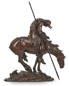 A bronze statue of an indigenous American man on horseback hunched over.