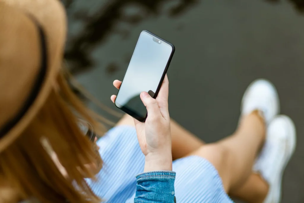 A generic photograph of a woman holding a smartphone