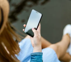 A generic photograph of a woman holding a smartphone
