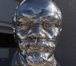 A stainless steel bust of Vladimir Lenin with a small figure of Mao Zedong balancing on top.
