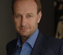 A half-length photograph portrait of a middle-aged Caucasian man in a suit.