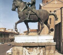 A large bronze statue of a man on horseback in front of a cathedral in Italy.
