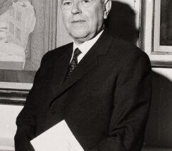 A photograph of René Magritte, an older man in a suit