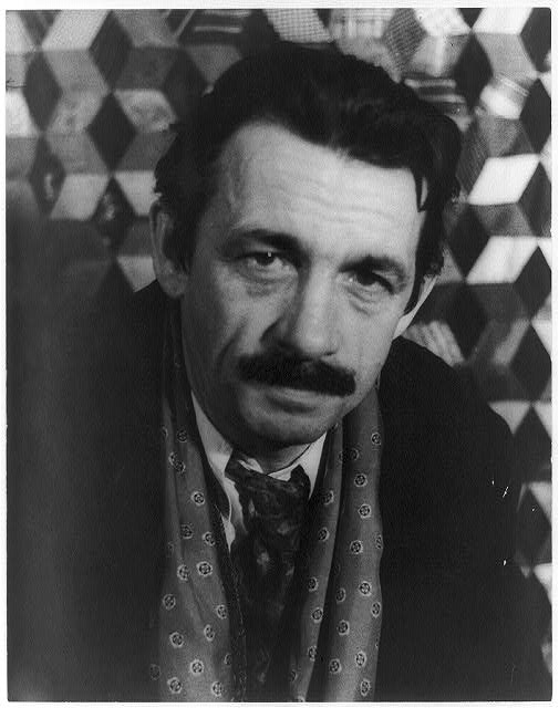 A black-and-white photograph of the painter Thomas Hart Benton, a middle-aged man with a thick moustache.