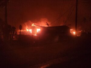 A photograph of a house on fire at night
