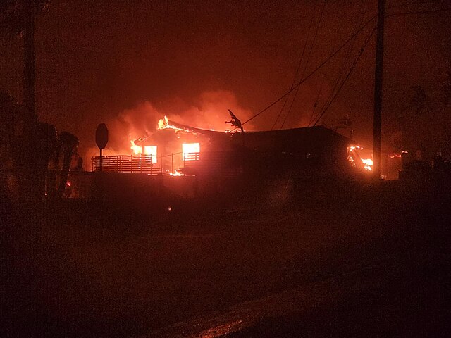 A photograph of a house on fire at night