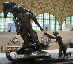 A bronze statue of a nude man being led away from a young woman by an older woman.