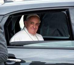 Pope Francis looking out the window of a car.