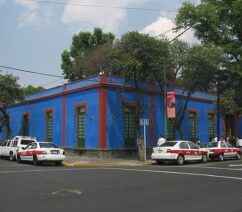A building on a street corner with the walls painted a vibrant cobalt blue.
