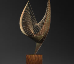 A sculpture of metal pieces curled into wing-like shapes decorated with strings,