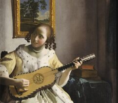 A woman in an ermine-lined coat playing a guitar.