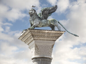 A bronze lion sculpture on top of a column