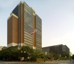 A large brick and glass building with an American flag out front.