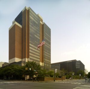 A large brick and glass building with an American flag out front.