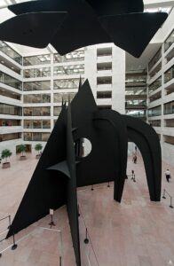 A large black metal sculpture in the atrium of an office building.