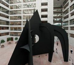 A large black metal sculpture in the atrium of an office building.