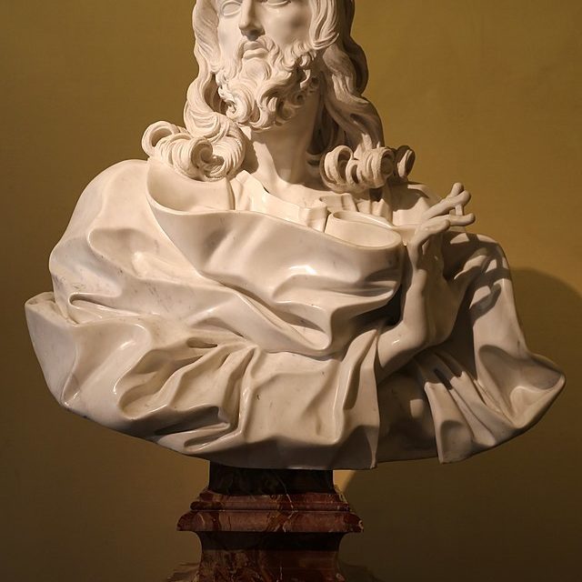 A marble bust of Christ draped in robes and his right hand extended in benediction.