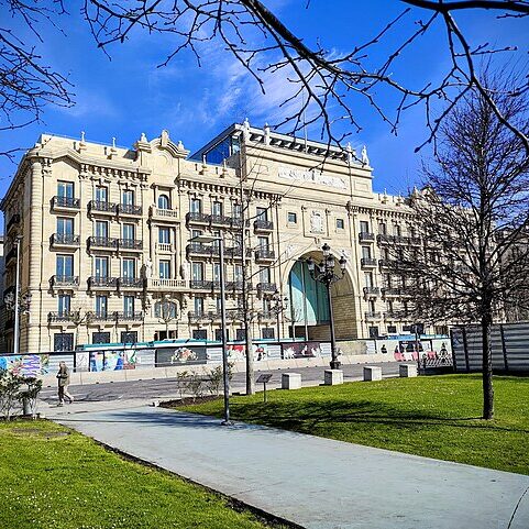 A large building adjacent to a park.