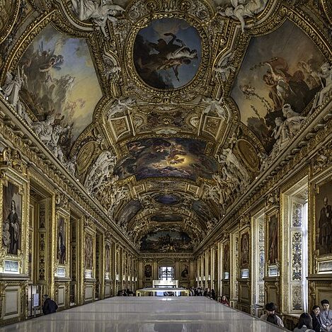 A large hall at the Louvre decorated with Baroque and Rococo decorative paintings.