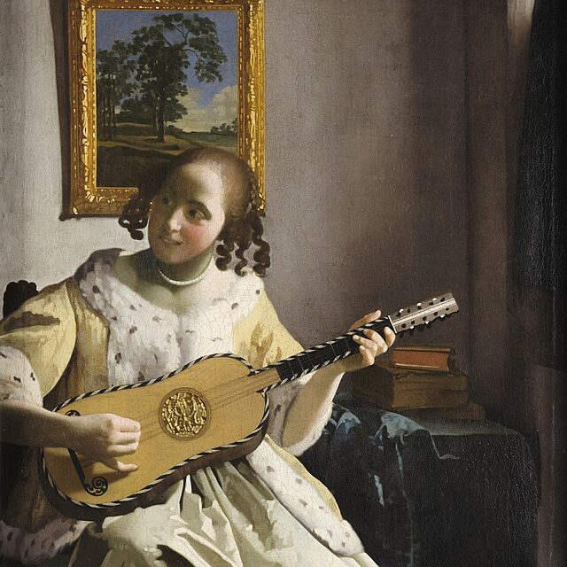 A woman in an ermine-lined coat playing a guitar.