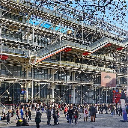 The Centre Georges Pompidou: a large, modern building that appears like there is scaffolding across the entire front as well as a long, jagged, tubular stairway running across the entire front.
