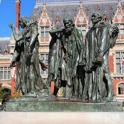 A bronze statue in a public square of six male figures with ropes around their necks
