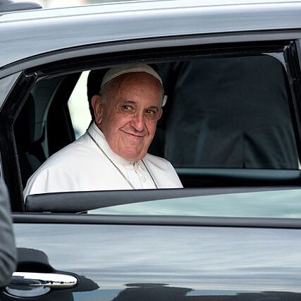 Pope Francis looking out the window of a car.