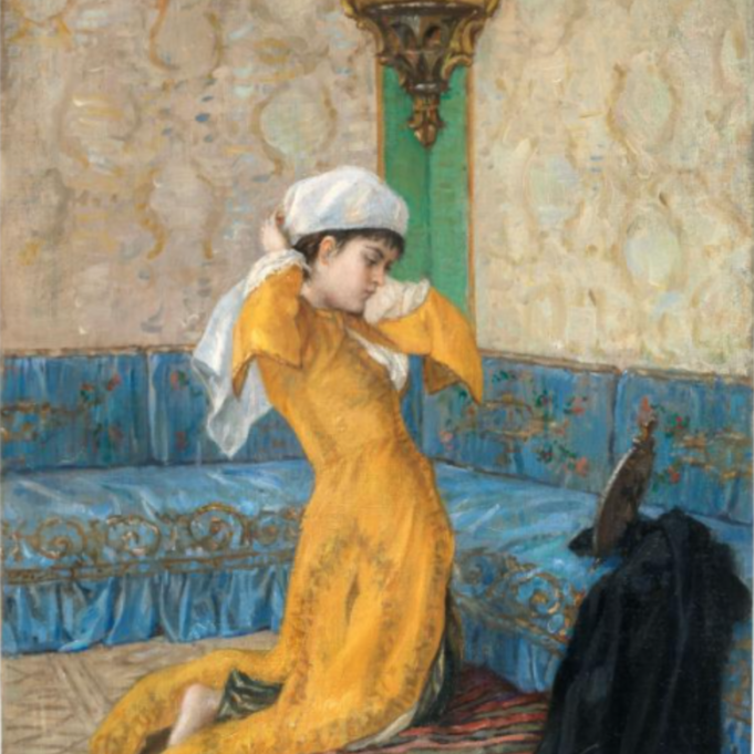 A painting offering an intimate look into a wealthy Ottoman woman's living space. She wears a yellow robe and kneels on a silk cushion as she puts on her head scarf.